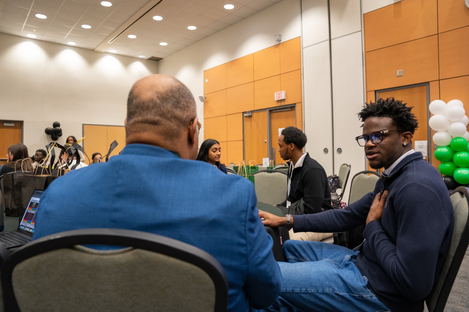 A member in conversation with a professional at the networking tables