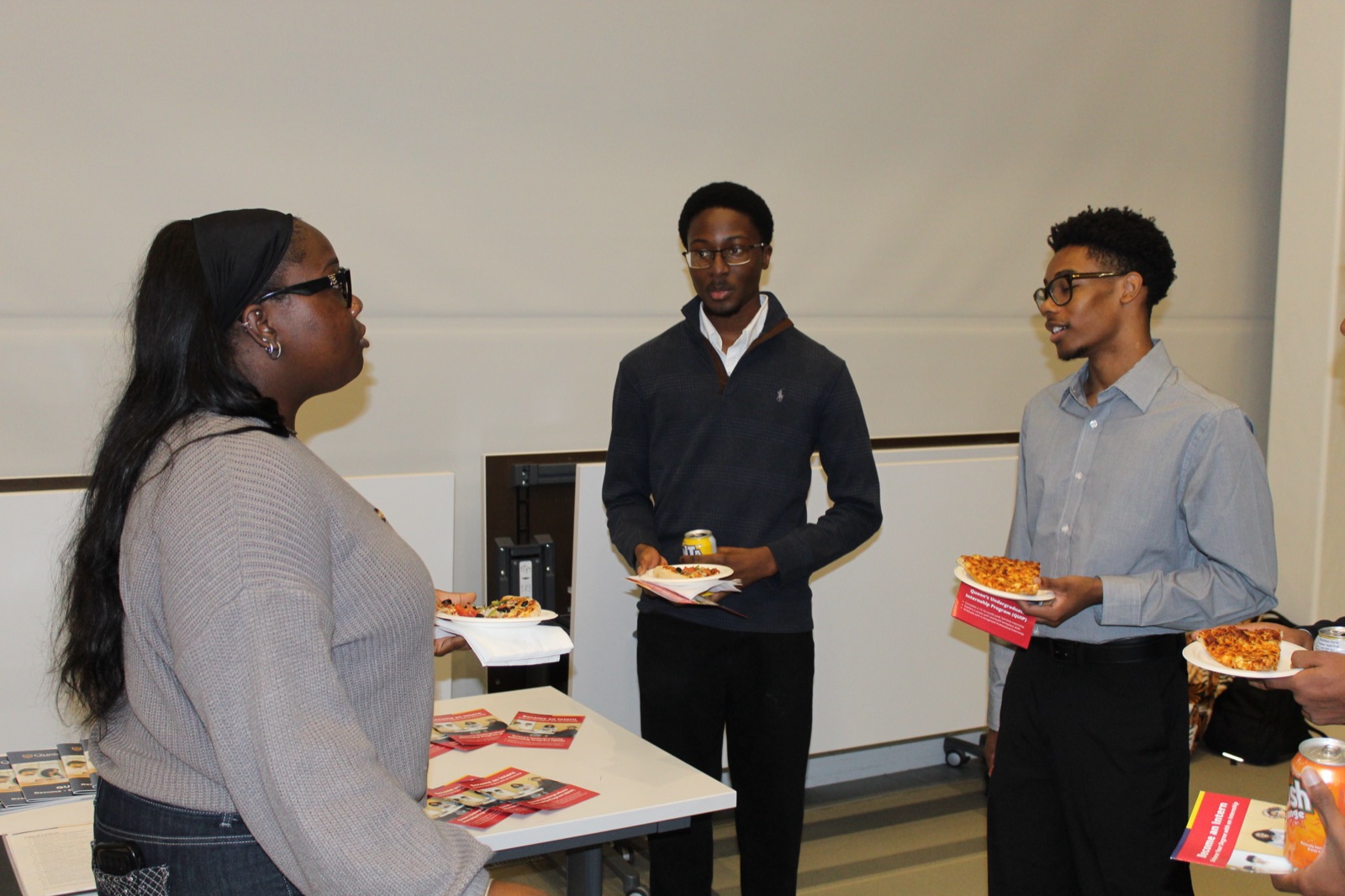 Members talking with a QUIP representative over food