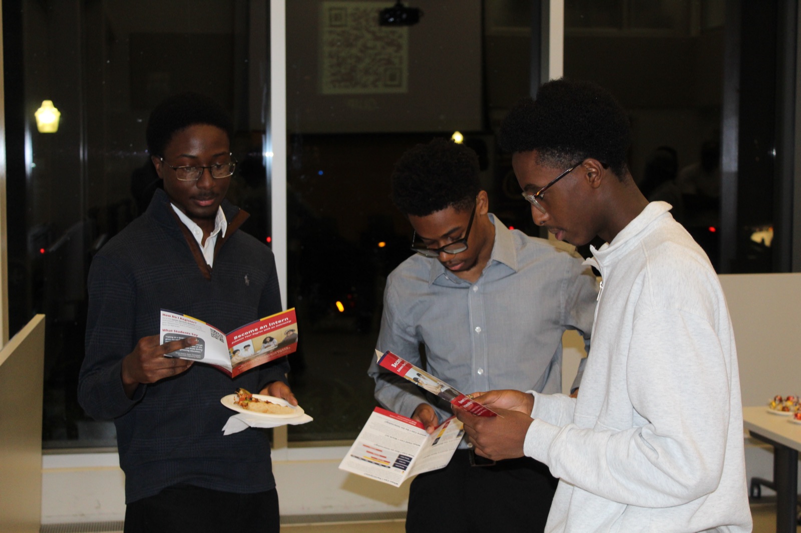 Members reading Queen's internship programme brochures
